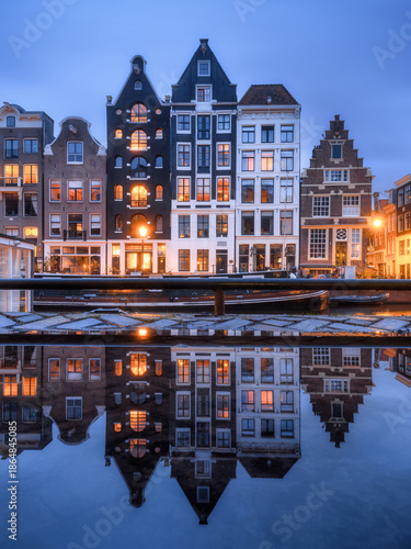 Iconic Amsterdam canals and traditional Dutch architecture at twilight with w...