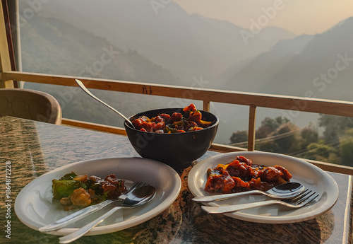 Mushrooms Manchurian dry in black bowl with beautiful view of mountains. Mushroom Manchurian - is indo chinese cuisine dish with deep fried mushrooms, bell peppers, sauce, capsicum and onion.