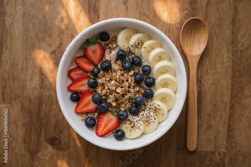 Vibrant Breakfast Bowl with Fresh Fruits, Granola, Chia Seeds, and Almond Milk on Wooden Table