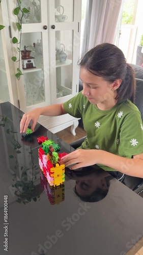 garota com autismo faz atividade com peças coloridas em casa 