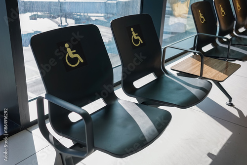 Wallpaper Mural Row of black chairs with golden wheelchair symbols in airport departure lounge with large windows overlooking tarmac and runways, accessibility and inclusive design concept Torontodigital.ca
