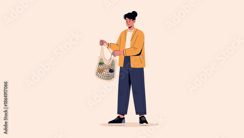 Modern woman shopping with reusable tote bag dressed in casual attire standing against a plain