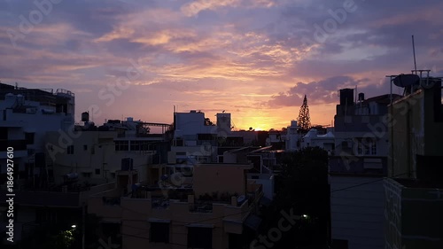 A panoramic sunset view over urban skyline beneath pink and blue sky likely in bangalore