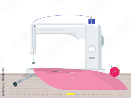 Sewing machine on wooden table with pink fabric and sewing supplies in a craft room