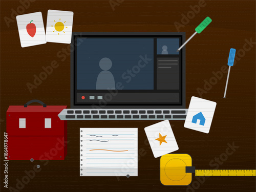 Computer with tools and drawings on a table during a creative activity at home