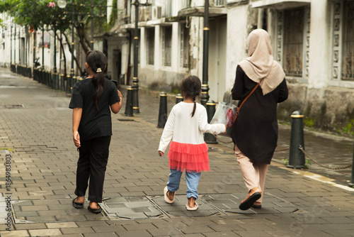 Mom and her Childreen walking at Urban Street Scene with Pedestrians and Historic Architecture