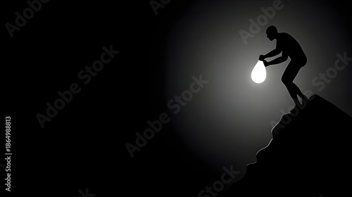 Man holding glowing light on mountain peak in dark silhouette