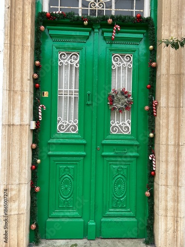 zielone drewniane drzwi przystrojone na święta bożonarodzeniowe