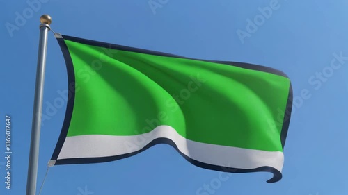 Waving Green Flag with White Stripe and Dark Border Against Clear Blue Sky