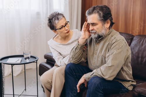 Psychologist counseling older man dealing with stress or headache