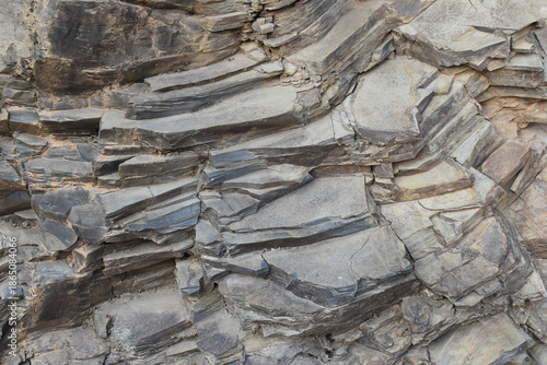 Close-up of a rough and textured rock surface. Raw stone surface showing organic shapes and lines. Earthy rock texture ideal for backgrounds or designs.