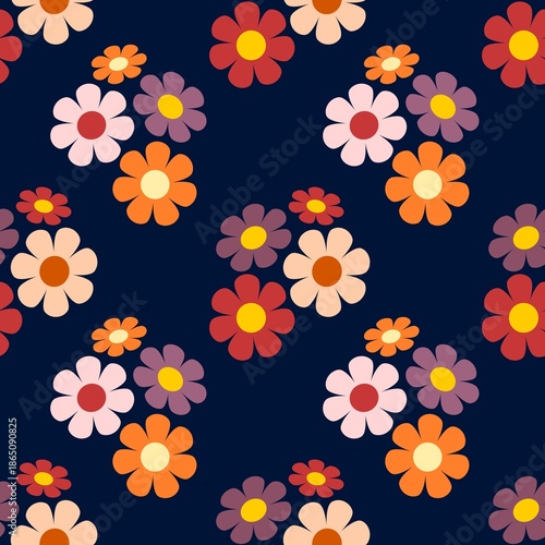 A seamless, vibrant retro floral pattern of simple flowers with rounded petals, in warm, contrasting shades of pink, orange, red, and purple on a blue background
