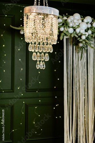 Decorative chandelier hangs under string lights in an event space for a special occasion