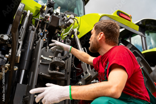 Canvas Print Male mechanic inspecting agricultural machinery