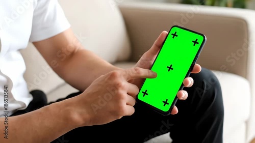 Person Using Smartphone with Green Screen in Casual Setting