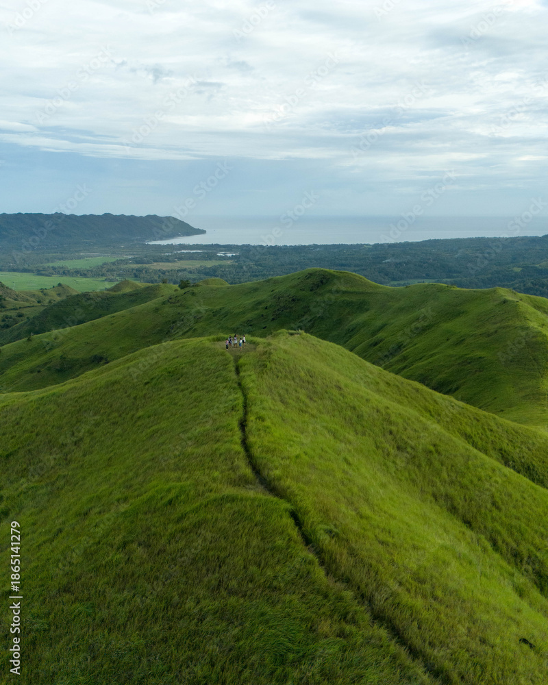 Obraz premium drone shot of green hill and blue sky
