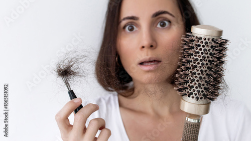 Photos Worried woman holding hairbrush and clump of fallen hair, suffering from hair l