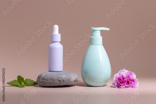 containers for skin care products on a stone podium and rose flowers on a beige background