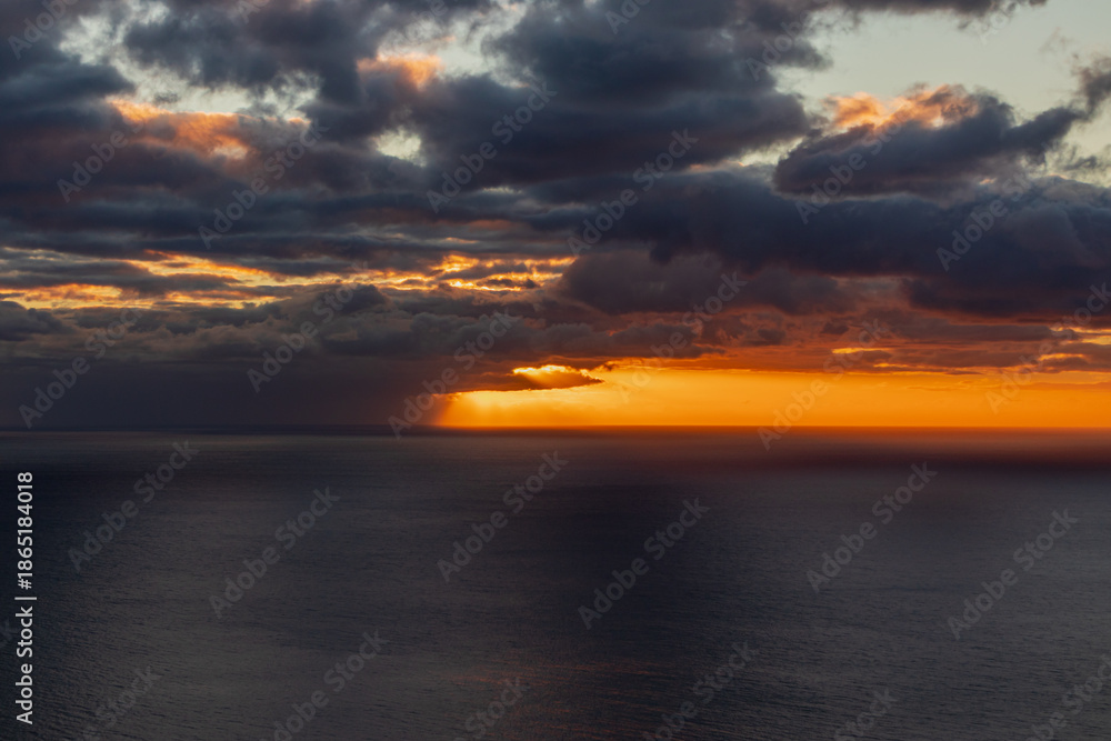 Obraz premium Beautiful sunset landscape at sea with dramatic, cloudy sky and bright orange horizon