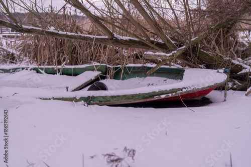a snow-covered boat on a frozen lake