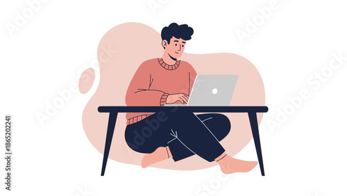 Young man working on laptop computer sitting on floor with crossed legs, remote work concept
