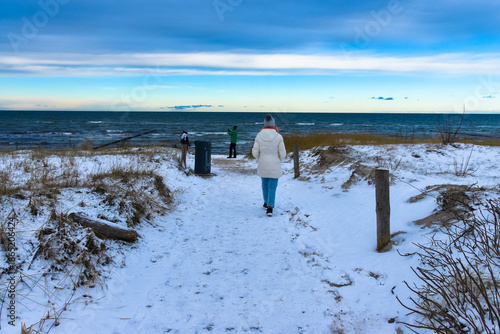  Spaziergänger im Winter am Strand der Ostsee, Insel Poel, am schwarzen Busch