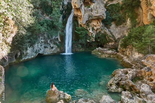 Young woman in bikini enjoying the crystal clear waters of La Calavera waterfall at Rio Borosa in Cazorla Natural Park Spain