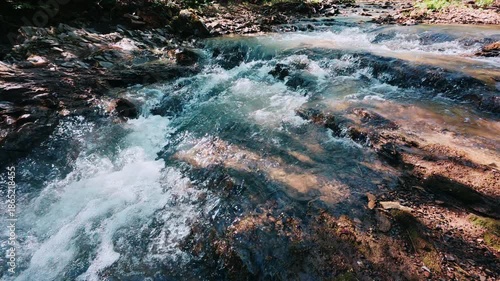 Wallpaper Mural Bubbling stream of mountain river in spring time. Water flows down stones in strong stream at sunny day. Nature concept	 Torontodigital.ca