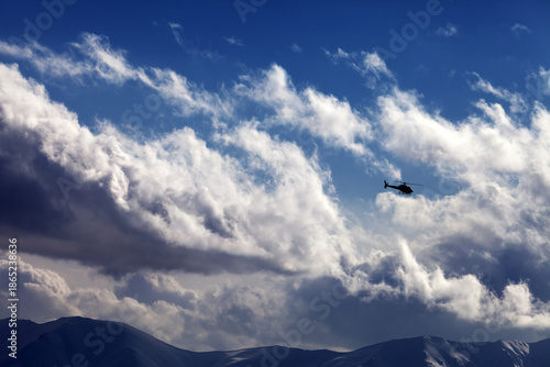 Helicopter in cloudy sky