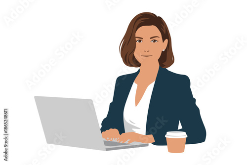 A confident woman in a suit works on a laptop with a coffee cup on her desk.