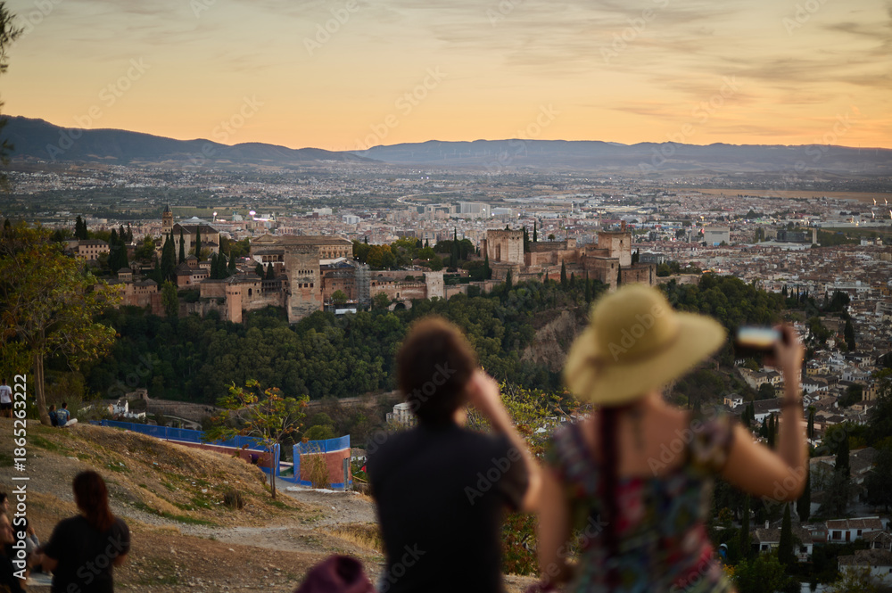 Obraz premium Tourists and locals watching the sunset over the Alhambra and Albaicin from San Miguel Alto