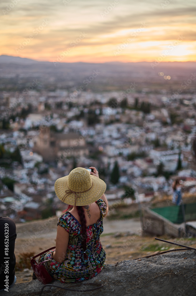Fototapeta premium Tourists and locals watching the sunset over the Alhambra and Albaicin from San Miguel Alto