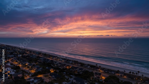 Birds-eye perspective of seaside homes glowing at sunset with urban lighting, ideal for editorial headers