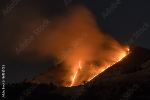Εκτύπωση καμβά Large wildfire burning on mountain slope at night in mountain