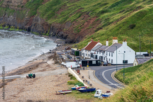 Coastal village scene with boats, road and cliffside homes in Saltburn by the Sea