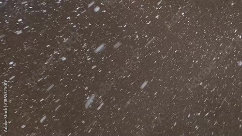Night snowfall with large snowflakes illuminated