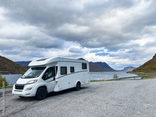 A motorhome parked by the road in the autumn landscape of the Lyngen Alps, Northern Norway, with mountains.