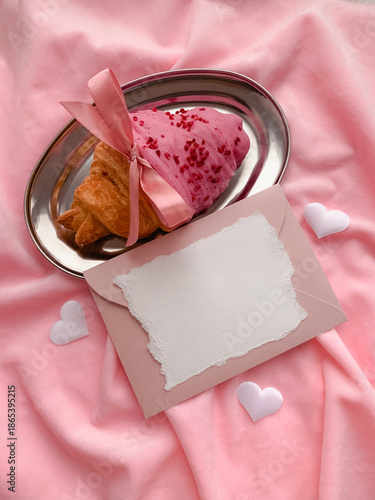 Strawberry croissant and envelope on a silver tray