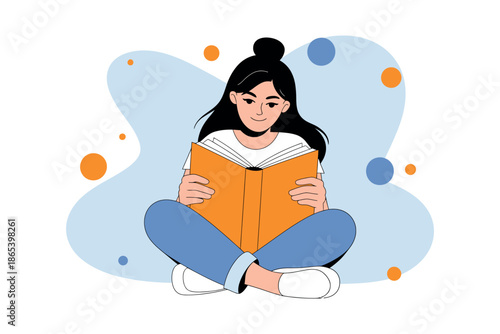 A young woman sitting comfortably reading a book with a peaceful expression