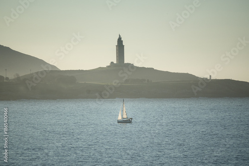 Tableau sur toile paisaje en el mar con un barquito y la torre de hercules