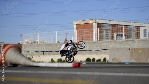 Motorcycle Stunt Rider Doing Wheelies and Acrobatics on Track