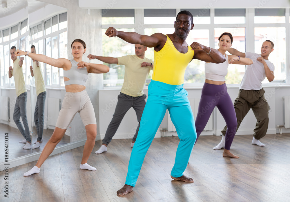 Fototapeta premium Happy African american man and group of international dancers training before big performance in modern dance class