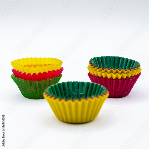 Stacks of colorful paper cupcake liners isolated on a white background. Baking supplies concept related to cupcakes, muffins, homemade desserts, party preparation, and food styling.