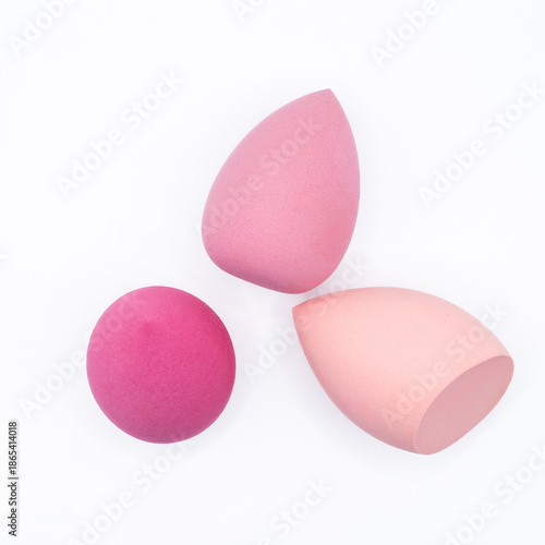 Three pink makeup sponges in different shapes isolated on a white background. Cosmetic beauty tools concept related to makeup application, skincare routine, beauty products, and personal care.