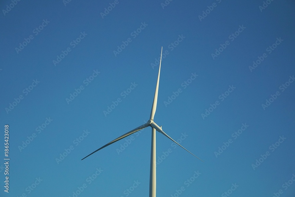 Fototapeta premium White Wind Turbine in a Very Blue Sky