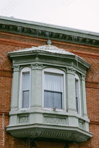 Balcony with ice and snow on a brick building during winter in a city setting