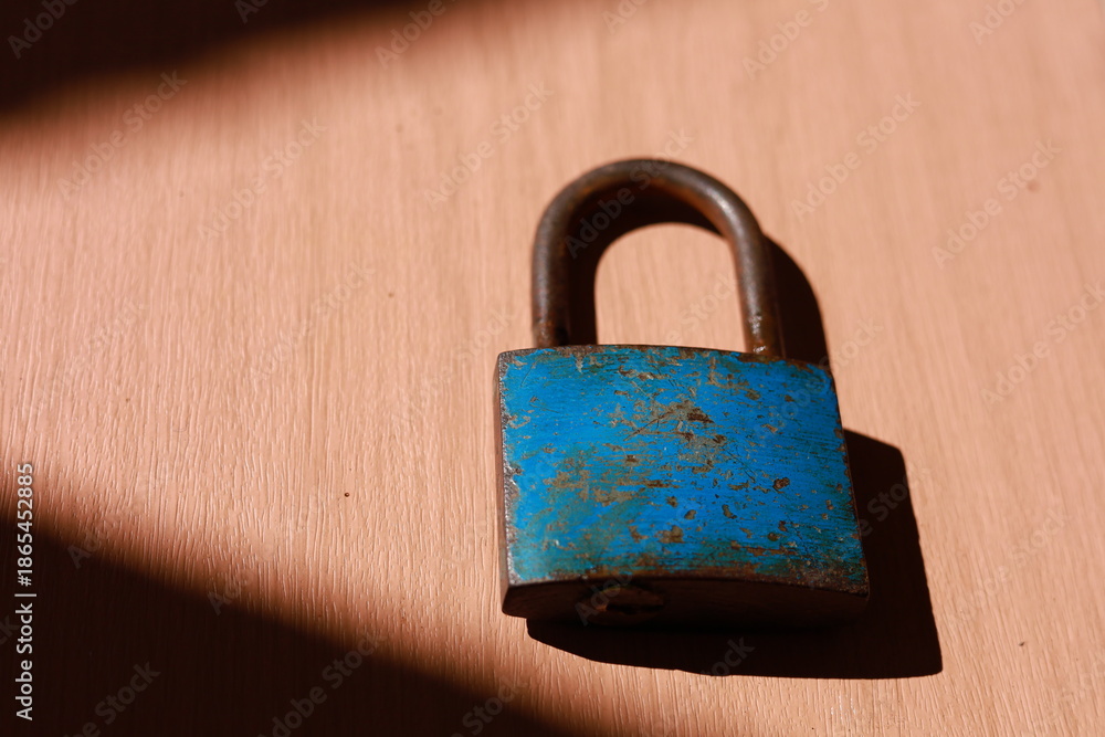 Fototapeta premium an old blue padlock on the wooden surface