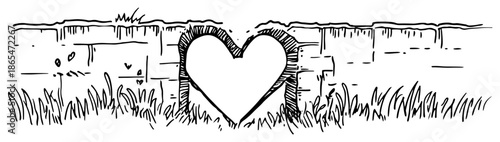 Heart shaped hole in an old brick wall with grass at the bottom