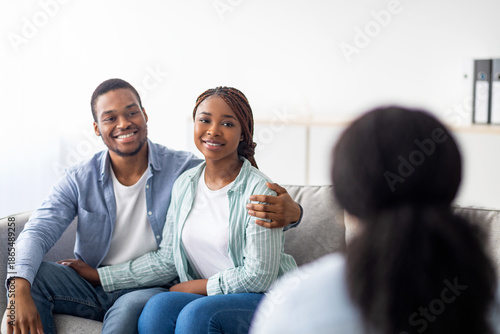 Wallpaper Mural Happy married couple after successful psychotherapy at marital counselor's office. Positive young black spouses sharing results with their psychologist, hugging on couch at clinic Torontodigital.ca