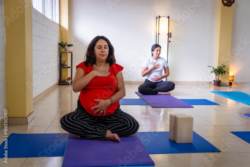Pregnant woman practicing yoga and meditation in class